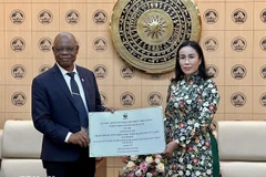 岘港市人民委员会副主席阮氏英诗与世界自然基金会（WWF）国家办事处主任马丁·卡巴鲁阿帕·卡平加。图自越通社