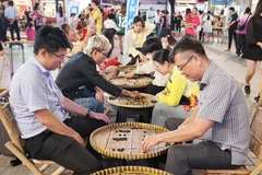 游客体验民间游戏。图自越通社