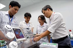 胡志明市工业大学电子技术学院教师引导学生学习和研究。图自越通社