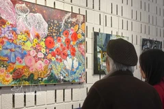 游客参观"在法兰西土地的越南之魂"画展与书展。图自越通社