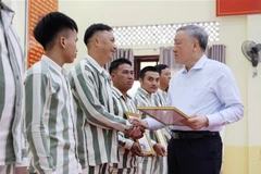 越共中央政治局委员、政府常务副总理、特赦咨询委员会主席阮和平向特赦人员颁发特赦决定。图自越通社