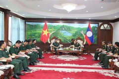 越南国防部副部长阮文贤中将礼节性拜见老挝国防部长坎良·奥萨宋。图自越通社