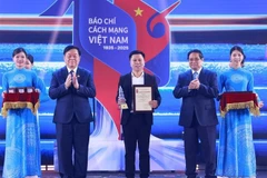 政府总理范明政向荣获2024年第十九届国家新闻奖一等奖的获奖者颁发奖状。图自越通社
