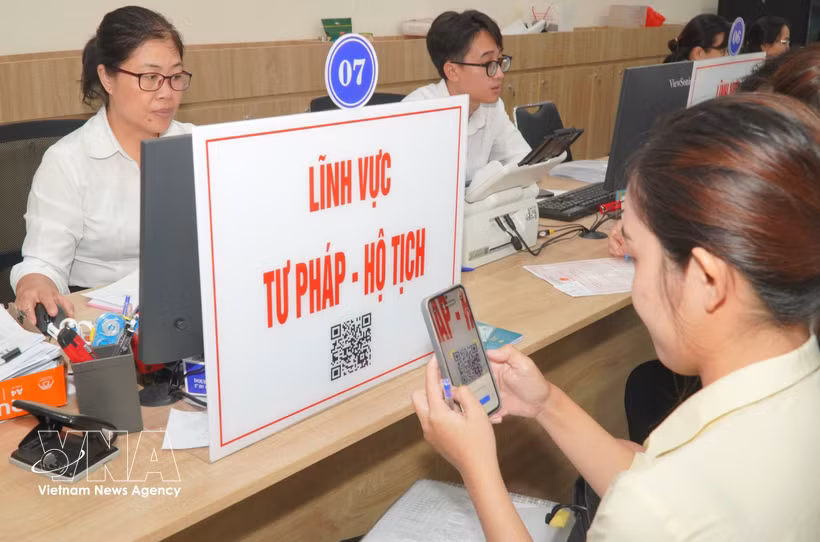 民众扫描二维码以查询司法领域的办事程序及档案流程。图自越通社
