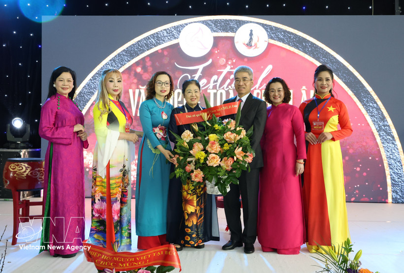 越南驻德国大使阮得成向欧洲越南女企业家协会主席郑氏未赠送鲜花表示祝贺。图自越通社