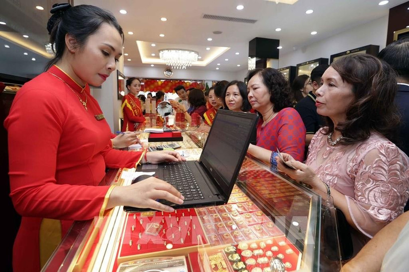 人们在孟海保信金店排队买黄金。图自越通社