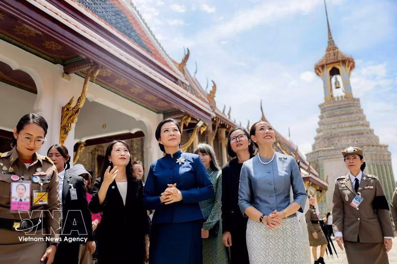 身着泰国传统服饰的吴芳璃夫人在塔纳农·参威拉军女夫人的陪同下，参观泰国大皇宫。图自越通社