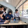 胡志明市国家大学下属理工大学学生进行高新技术应用实践操作。图自越通社
