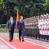 国家主席梁强和法国总统埃马纽埃尔·马克龙检阅仪仗队。图自越通社