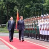 国家主席梁强和法国总统埃马纽埃尔·马克龙检阅仪仗队。图自越通社