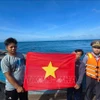职能力量向渔民赠送国旗。图自越通社