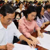 代表们研究第十六届国会代表候选人资料。图自越通社