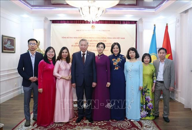越共中央总书记苏林与夫人同越南驻哈萨克斯坦大使馆干部和工作人员合影。图自越通社 gap-go-can-bo-dai-su-quan-va-cong-dong-nguoi-viet-nam-tai-kazakhstan-stand.jpg