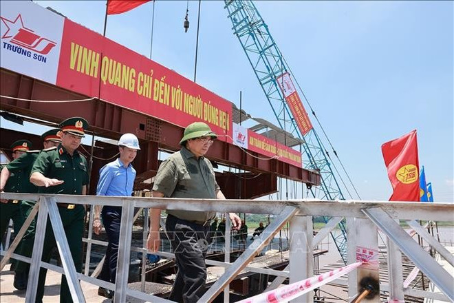 范明政总理视察新丰洲大桥跨施工进度。图自越通社 cau-phong-chau.jpg