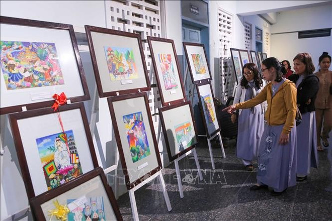 游客参观关于2025年岘港市五行山郡观世音庙会的画展。图自越通社 da-nang-khai-mac-le-hoi-quan-the-am-ngu-hanh-son-nam-2025-stand.jpg