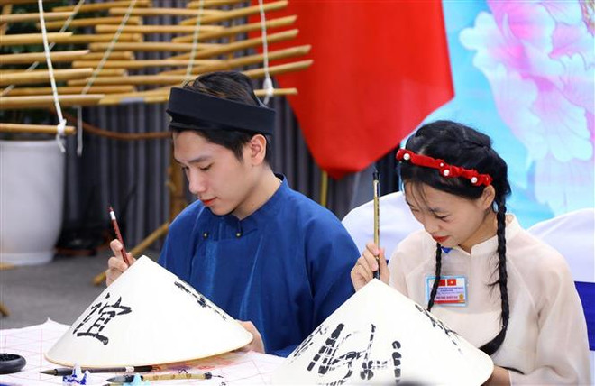 越南国家主席夫人和中共中央总书记、中国国家主席夫人与河内国家大学学生交流 ảnh 2