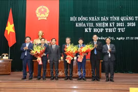 向黎鸿荣同志与黎文保同志赠送鲜花。图自越通社