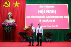 中央组织部代表向陈志光同志授予决定。图自越通社