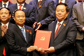 中央宣传与群众工作部部长阮仲义向蔡大玉同志授予决定。图自越通社