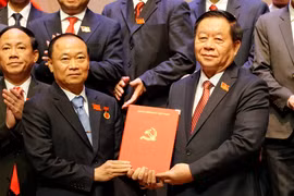 中央宣传与群众工作部部长阮仲义向蔡大玉同志授予决定。图自越通社