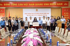 越南卫生部长陶红蓝向中央救济动员委员会代表赠送驰援款项。图自越通社