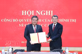 中央组织部部长黎明兴向越共中央委员、庆和省委副书记、省人民委员会主席陈峰颁发中央政治局的任命决定书。图自越通社