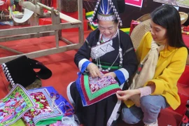 游客探索老街省芒姜巴迪族同胞传统服饰制作。图自越通社