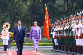 越南政府总理范明政与泰王国总理佩通坦·钦那瓦出席检阅仪仗队。图自越通社
