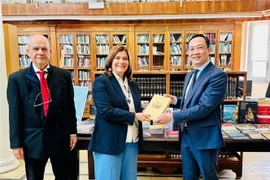 杨海兴大使向塞浦路斯文化部副部长瓦西丽姬赠送书籍。图自越通社