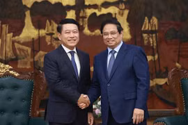 越南政府总理范明政与老挝副总理、人民革命党中央企业改革委员会主任沙伦塞·贡马西合影。越通社