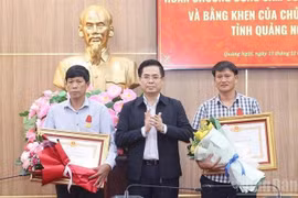 广义省人民委员会主席阮黄江向李山特别行政区西安永村潘维光先生和李山特别行政区西安海村黎文生先生授予勇气勋章。图自越通社