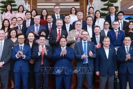 范明政总理同与会代表合影。图自越通社