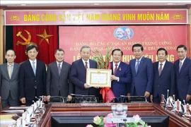 苏林总书记向潘廷镯同志颁发45年党龄纪念章。图自越通社