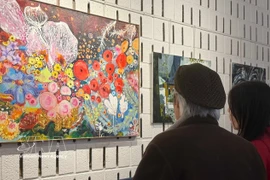 游客参观"在法兰西土地的越南之魂"画展与书展。图自越通社