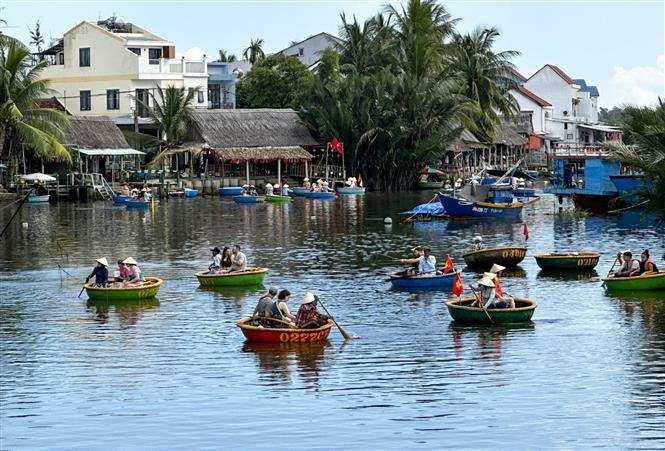 2025年前九个月，岘港市接待游客超过1440万人次，同比增长逾22%。其中，国际游客580万人次，同比增长超过31%。图为：国际游客在岘港市锦清旅游村体验乘坐簸箕船。图自越通社