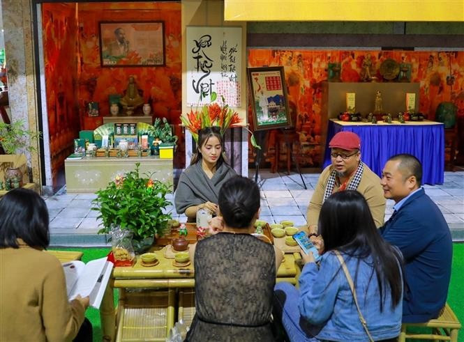 在微凉秋意中,游客一边品茶,一边欣赏传统手工艺村展位的精美作品,感受河内秋天独特的韵味。图自越通社