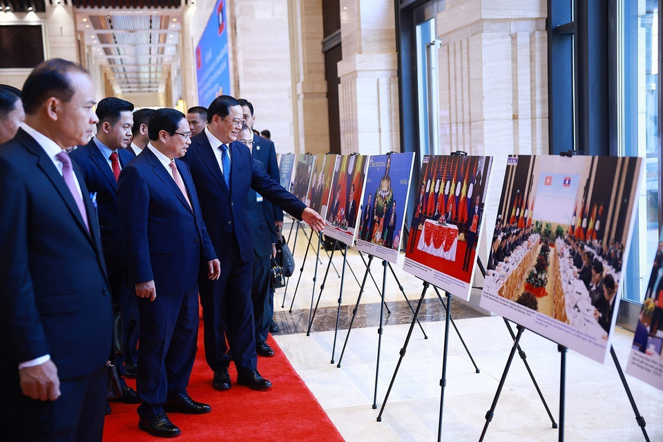 越南政府总理范明政与老挝政府总理宋赛·西潘敦共同参观两国合作图片展。图自越通社