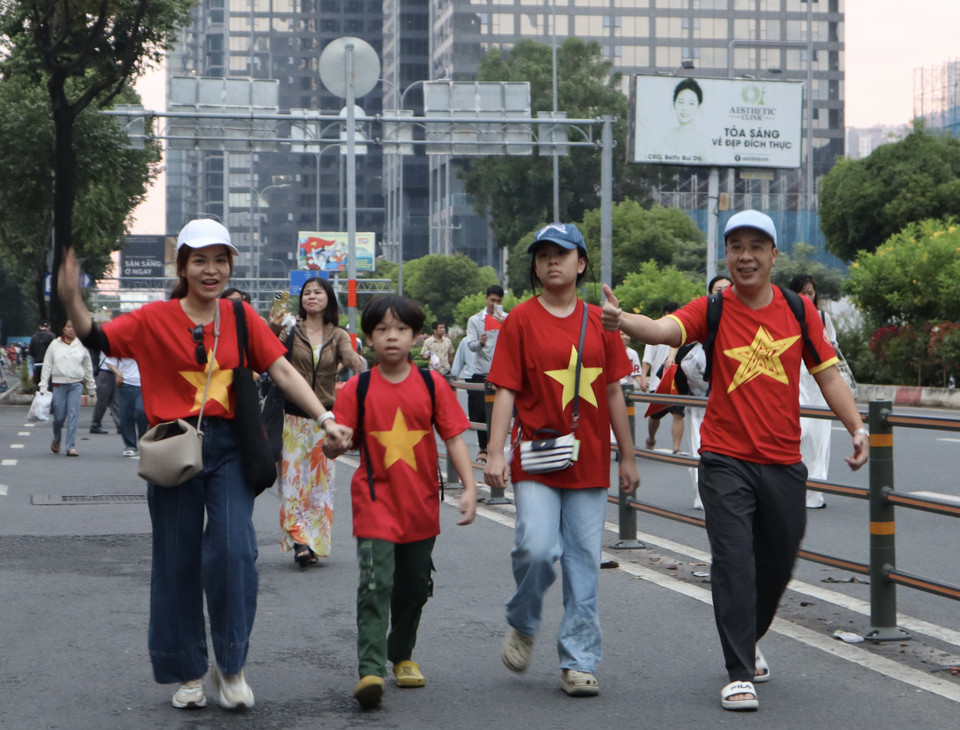 不少家庭兴致勃勃地前往现场，等待观看纪念南方解放、国家统一50周年庆典阅兵和游行活动的总彩排。图自 越通社