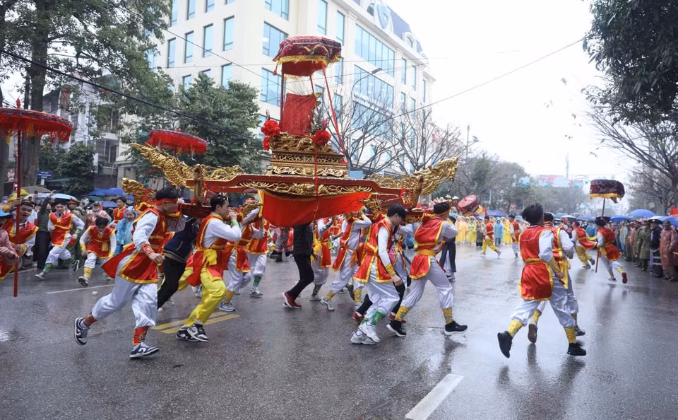 庙会包括祭祀仪式、轿子游行以及多种独特民间游戏和表演。图中：从淇穷祠到左府祠途中进行的转轿仪式。图自越通社
