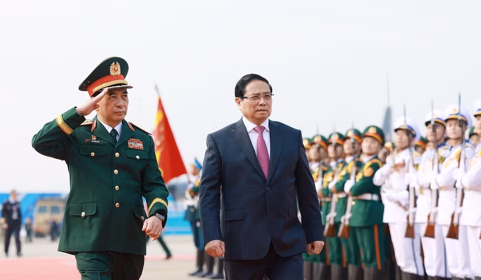 越南国防部长潘文江大将迎接范明政总理前来出席2024年越南国际防务展开幕式。图自越通社