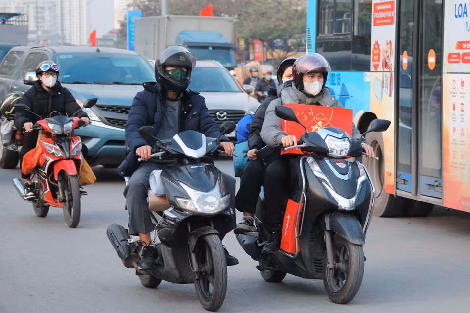 人们带着行李离开河内，朝 1A 国道前进。图自越通社