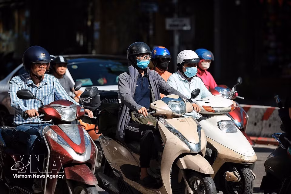 河内市中心各主要街道上的民众纷纷穿戴防晒衣物、墨镜和口罩，以抵御从清晨开始持续攀升的高温天气。图自越通社