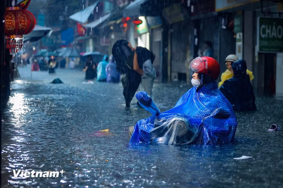 旁晚时，大雨仍然倾泻而下，正值下班高峰，街道积水无法排出。图自越通社