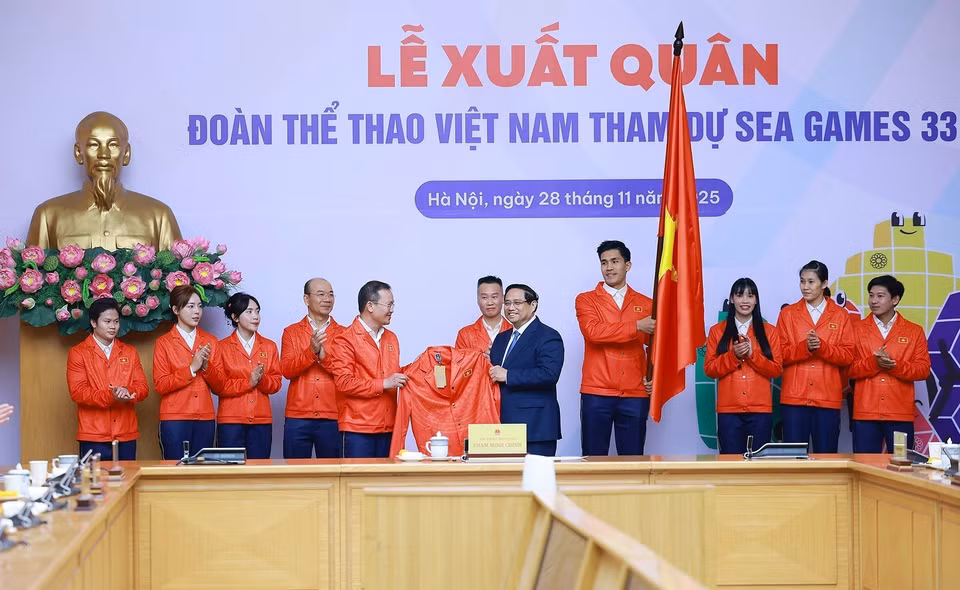 参加第33届东南亚运动会的越南体育代表团向政府总理范明政赠送比赛服装。图自越通社