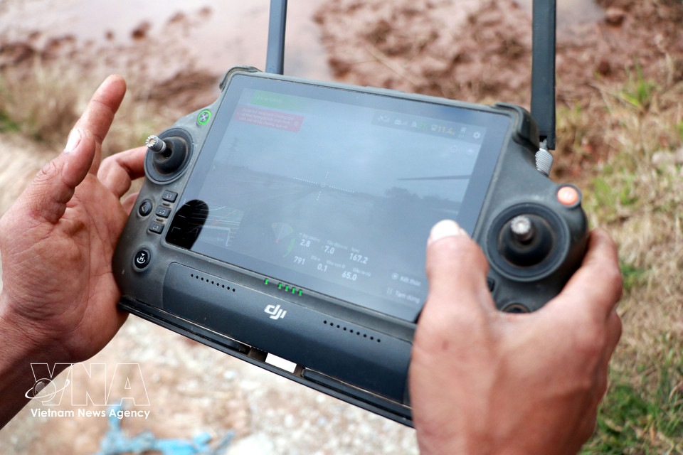 宁平省义兴乡南大洋青年合作社成员操作无人机设备进行水稻播种。图自越通社