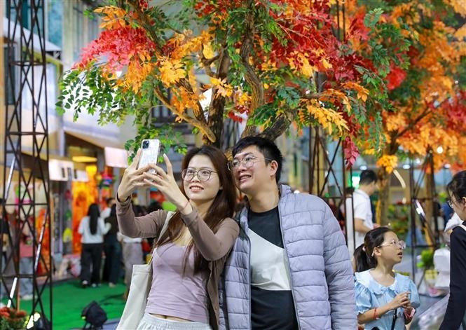 市民与“河内秋季之路”打卡留念。图自越通社
