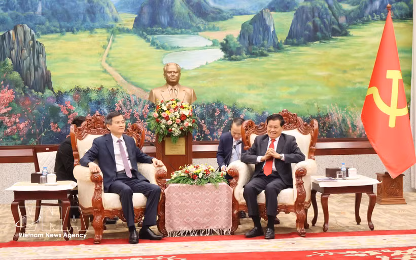 老挝人民革命党中央总书记、国家主席通伦·西苏里（右）会见前来礼节性拜会的越共中央政治局委员、胡志明国家政治学院院长段明训副教授。图自越通社 