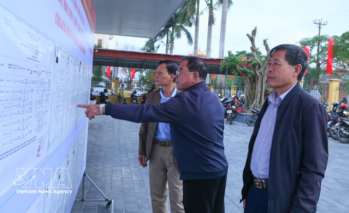 海进乡第三投票区的选民正在了解国会代表及各级人民议会代表候选人的相关信息。图自越通社