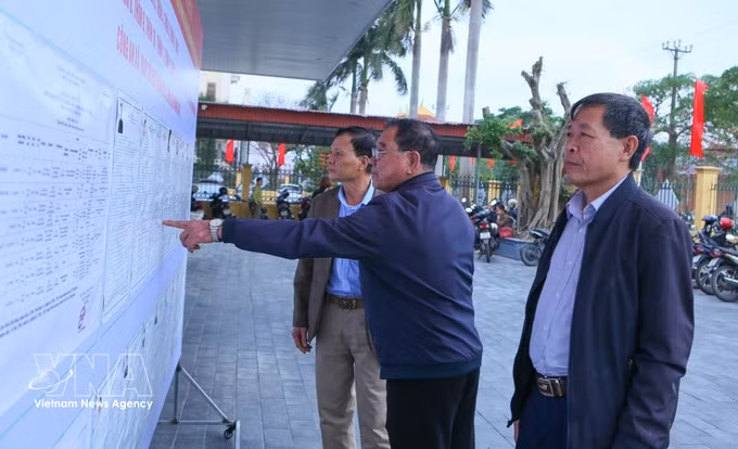海进乡第三投票区的选民正在了解国会代表及各级人民议会代表候选人的相关信息。图自越通社