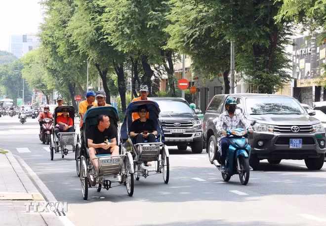 游客乘坐人力三轮车参观胡志明市中心。图自越通社
